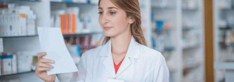 A skilled and experienced allied health professional (AHP), possibly a pharmacist, reviewing a prescription in a well-stocked pharmacy. This image highlights the demand for experienced AHPs in the healthcare sector and how Hunter Gatherer AHP connects skilled professionals with rewarding opportunities.