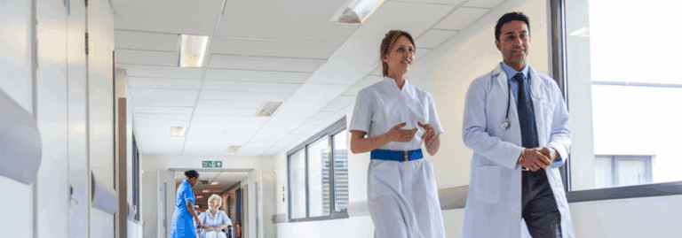 A diverse team of healthcare professionals, including doctors, nurses, and allied health professionals (AHPs), working together in a hospital corridor. Their collaboration represents the importance of teamwork in providing high-quality patient care. At Hunter Gatherer AHP, we focus on building resilient AHP teams to meet the growing demand for healthcare services and ensure improved patient outcomes through effective recruitment strategies.