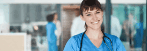 Smiling healthcare professional in scrubs reviewing patient notes, representing flexible locum work opportunities for AHPs