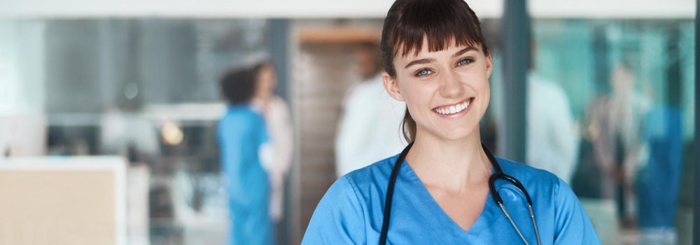 Smiling healthcare professional in scrubs reviewing patient notes, representing flexible locum work opportunities for AHPs