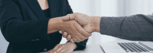 A professional handshake between two individuals, representing the collaboration and skills employers seek in AHP candidates in 2025. Learn more in our latest blog at Hunter Gatherer AHP.
