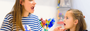 A paediatric Speech and Language Therapist placed by Hunter Gatherer AHP working with a young child on speech articulation in a clinical therapy setting.