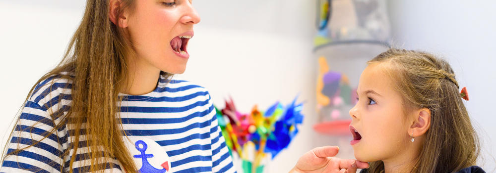 A paediatric Speech and Language Therapist placed by Hunter Gatherer AHP working with a young child on speech articulation in a clinical therapy setting.
