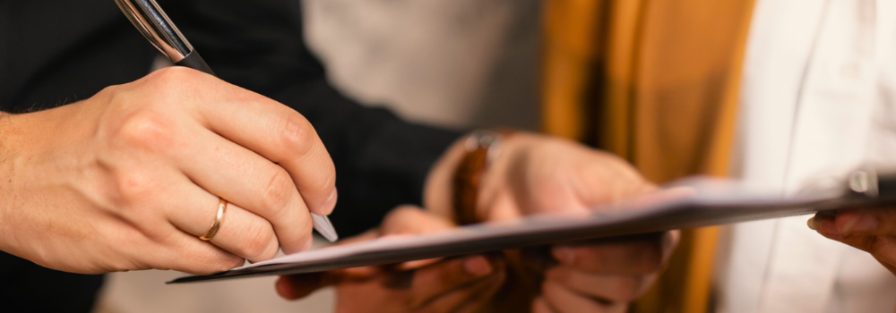 Close-up of a compliance professional at Hunter Gatherer AHP completing documentation and verifying credentials as part of the AHP recruitment process.