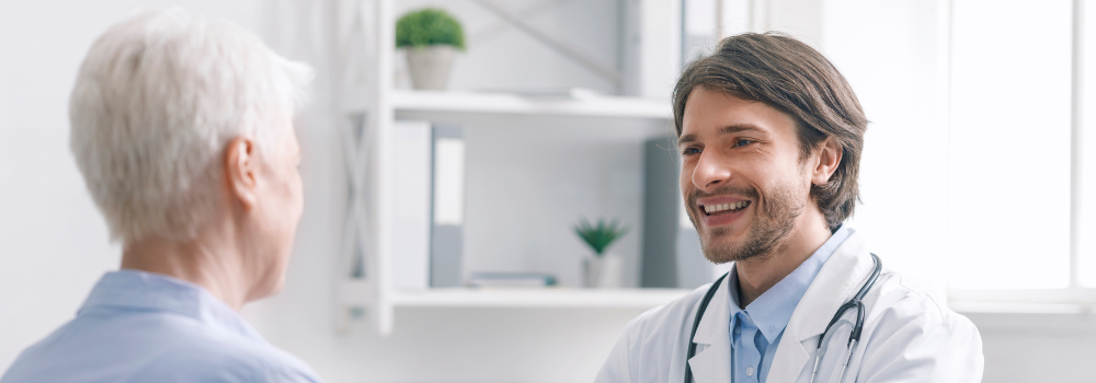 Primary Care locum doctor smiling with a patient during consultation