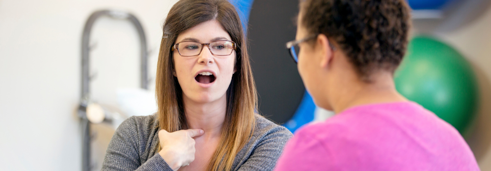 Speech and Language Therapist working with an adult patient to improve speech and communication skills in a clinical setting
