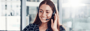 Smiling recruitment consultant speaking with a client on a headset, representing trusted AHP recruitment support at Hunter Gatherer AHP